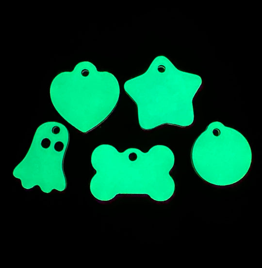 Three glow in the dark tags showing their off-white color when not glowing, and the black lettering that shows through after engraved.