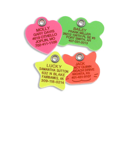 A group of brightly colored plastic tags with personalized engraving, including a neon pink heart, a neon green bone, a neon yellow star, and a neon orange-ish cat face.